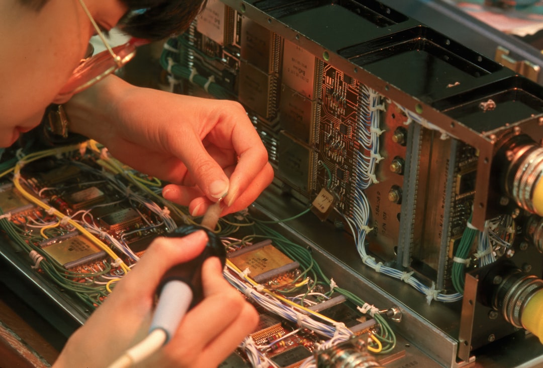 hands soldering components on a vintage amplifier circuit board
